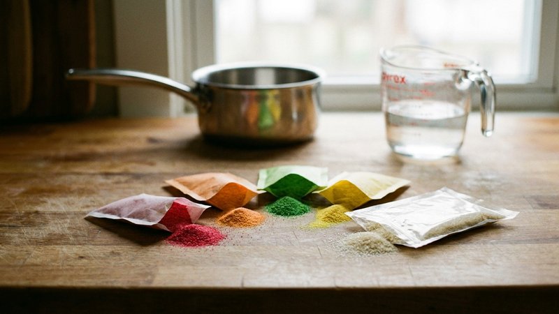 sobres de gelatina sin sabor y gelatina de sabor sobre una mesa