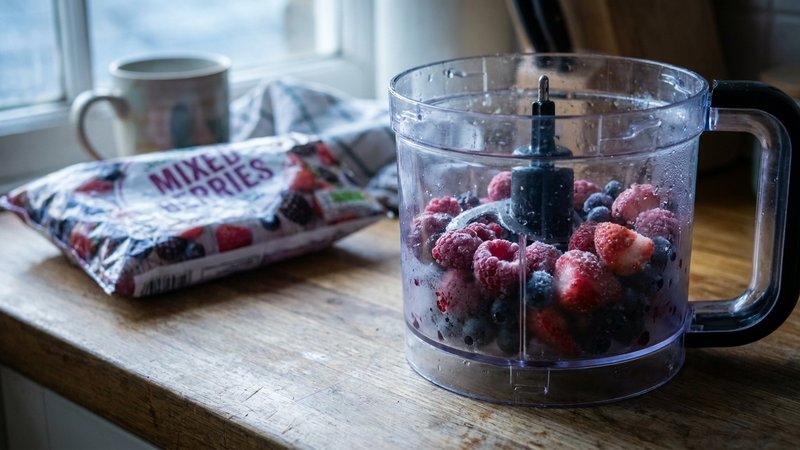 procesadora con frutos rojos congelados recién triturados