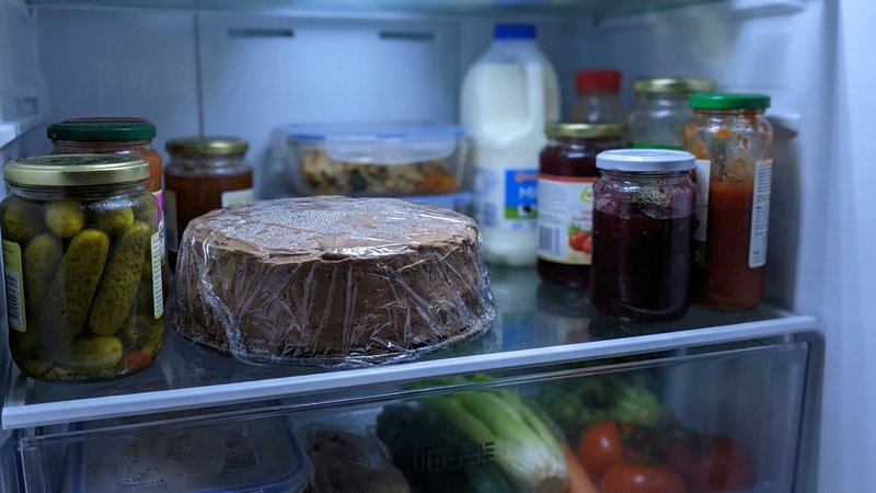 pastel de chocolate envuelto guardado en el refrigerador