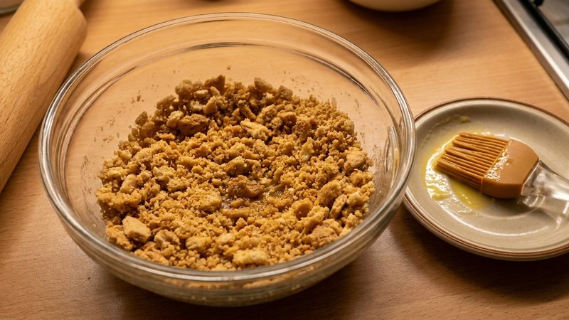 galletas trituradas mezcladas con mantequilla derretida