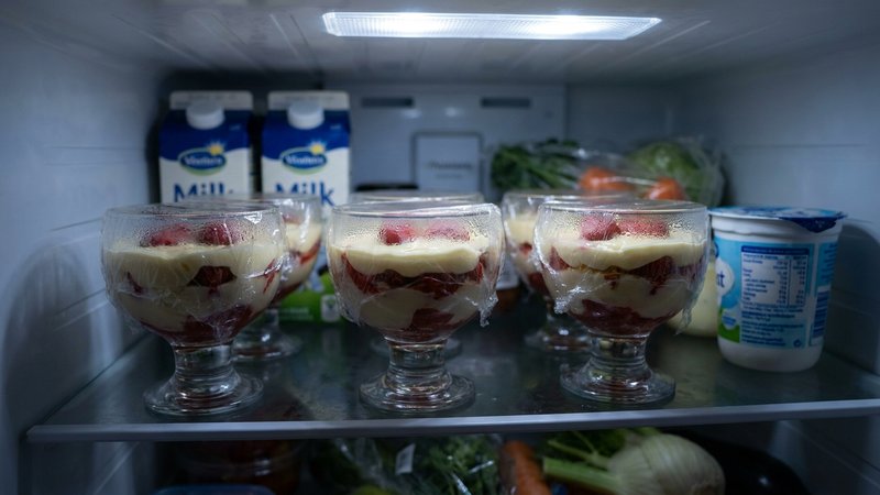 vasitos de postre de fresa cubiertos en el refrigerador